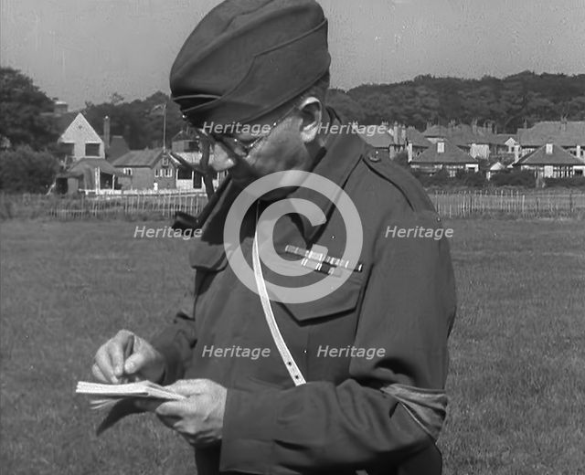 A British Local Defence Volunteer Writing Notes, 1940. Creator: British Pathe Ltd.