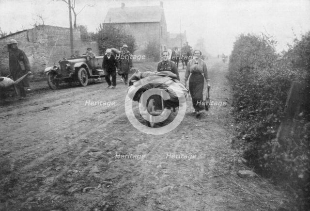 A British soldier helping a woman return to her village, France, 1918. Artist: Unknown
