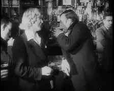 A British Woman and a British Man Standing at the Bar Holding Drinks in a Public House..., 1939. Creator: British Pathe Ltd