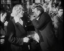 A British Woman and a British Man Standing at the Bar Holding Drinks in a Public House..., 1939. Creator: British Pathe Ltd