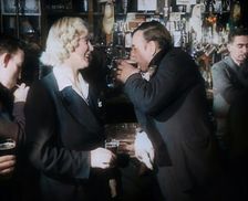A British Woman and a British Man Standing at the Bar Holding Drinks in a Public House..., 1939. Creator: British Pathe Ltd