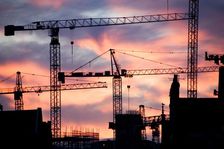 A building site at sunset with cranes silhouetted against a red sky, 2007. Artist: Historic England Staff Photographer