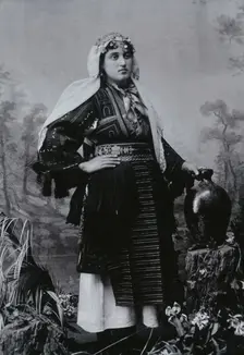A Bulgarian woman in national dress with a water jug, early 20th century. Creator: Unknown