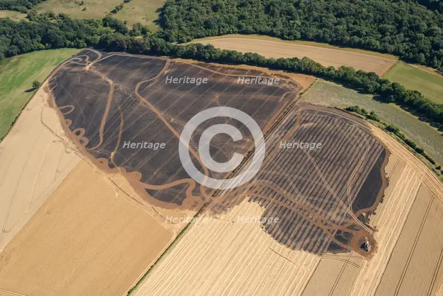 A burnt out combine harvester and fire scorched fields near Pleasley, Derbyshire, 2022. Creator: Emma Trevarthen.