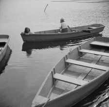 A camper returning a boat to the dock at Camp Gaylord White, Arden, New York, 1943. Creator: Gordon Parks
