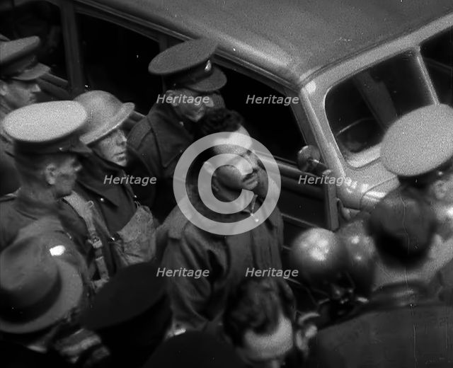 A Captured Italian Pilot Being Escorted Through a Train Station, 1940. Creator: British Pathe Ltd.