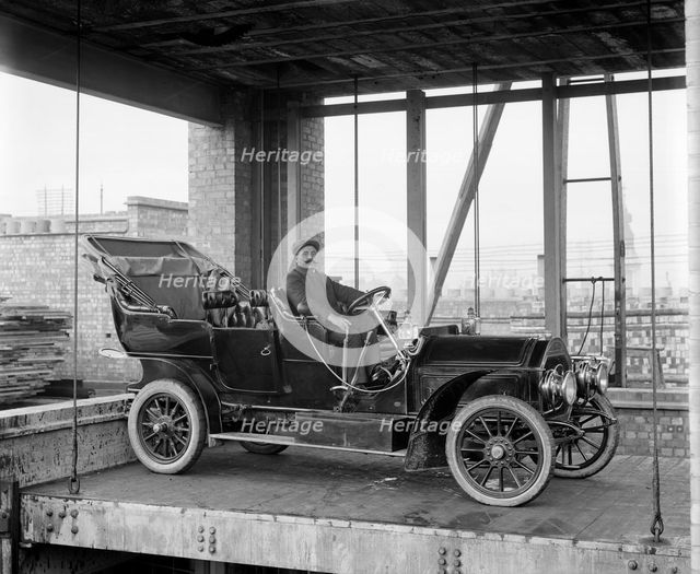 A car and chauffeur in the car lift at Mitchell's Motors, Wardour Street, London, 1907. Artist: Bedford Lemere and Company