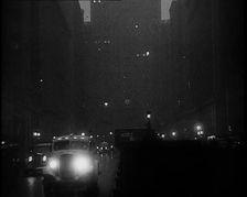 A Car Driving Towards the Camera With Very Bright Head Lights On the Streets of New York..., 1932. Creator: British Pathe Ltd