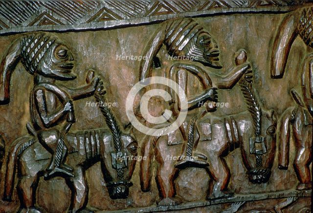 A carved wooden door from Nigeria depicting men on horseback. Artist: Unknown