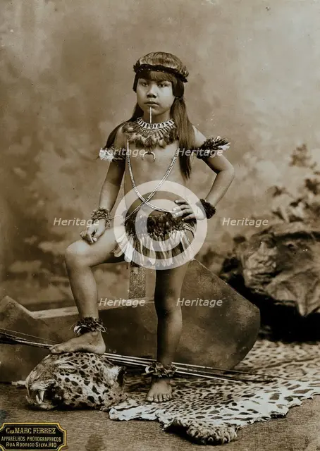 A child of an Amazonian Indian tribe, standing on a leopard skin, in a photographic studio, 1900. Creator: Unknown.