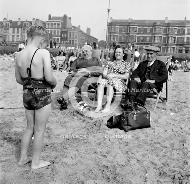A child photographs his mother and grandparents on the beach, Blackpool, c1946-c1955. Artist: John Gay