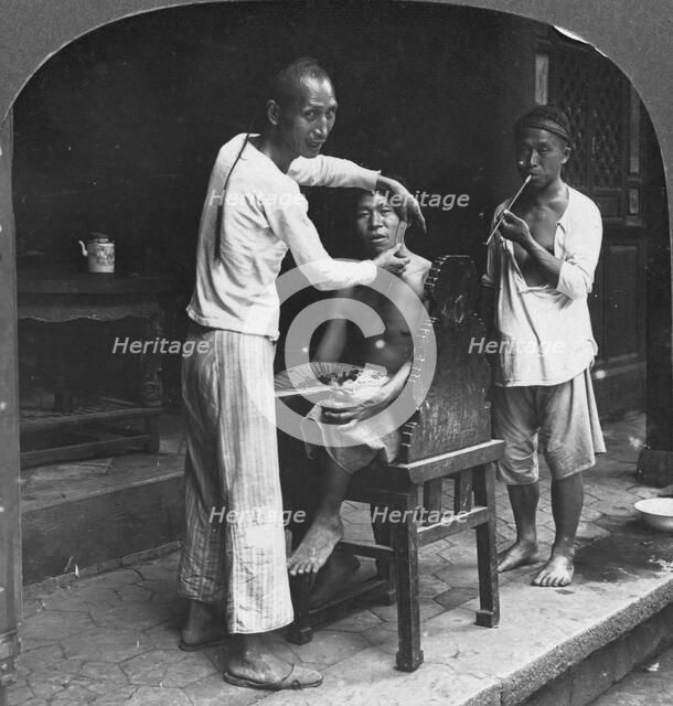 A Chinese barber at Bhamo, Burma, 1908. Artist: Stereo Travel Co