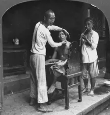 A Chinese barber at Bhamo, Burma, 1908. Artist: Stereo Travel Co