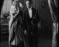 A Civilian Couple Wearing Evening Outfits Ready to Leave for an Event, the Male Holds a Top..., 1920 Creator: British Pathe Ltd