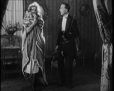 A Civilian Couple Wearing Evening Outfits Ready to Leave for an Event, the Male Holds a Top..., 1920 Creator: British Pathe Ltd