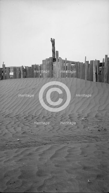 A corral practically buried by drifted dust, Mills, New Mexico., 1935. Creator: Dorothea Lange.