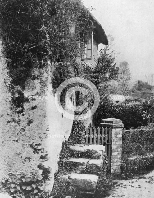 A cottage with an ancient 'upping stock', Cockington, Devon, 1924-1926.Artist: HJ Smith