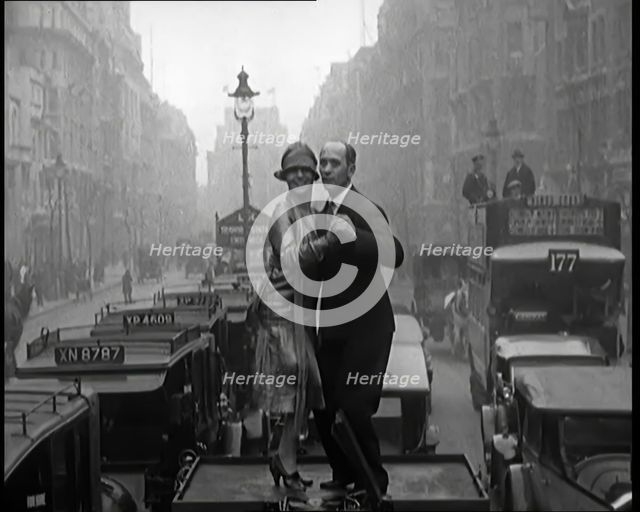 A Couple Dancing the Charleston on the Top of a Car Driving Down a London Street, 1926. Creator: British Pathe Ltd.