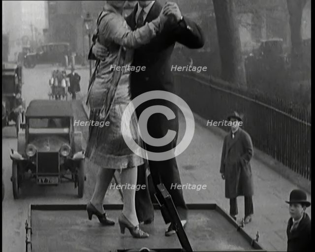 A Couple Dancing the Charleston on the Top of a Car Driving Down a London Street, 1926. Creator: British Pathe Ltd.