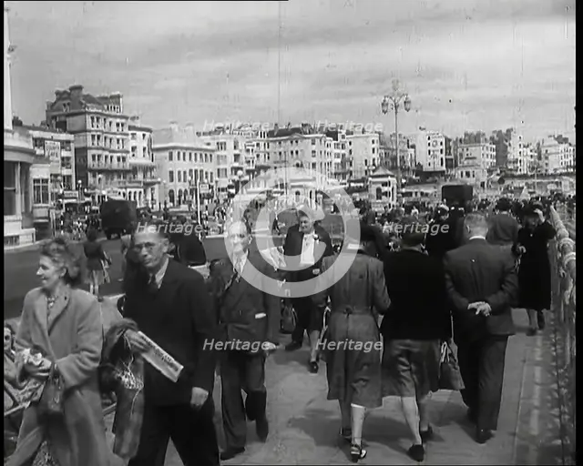 A Cloudy Day as Male and Female Pedestrians are Walking on the Promenade at  Brighton..., 1939. Creator: British Pathe Ltd.