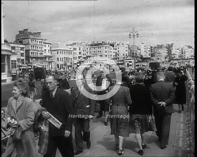 A Cloudy Day as Male and Female Pedestrians are Walking on the Promenade at  Brighton..., 1939. Creator: British Pathe Ltd.