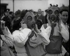 A Close up of Three Female Civil Defence Volunteers in White Boiler Suits Putting on Gas..., 1938. Creator: British Pathe Ltd