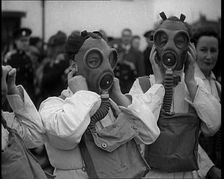 A Close up of Three Female Civil Defence Volunteers in White Boiler Suits Putting on Gas..., 1938. Creator: British Pathe Ltd