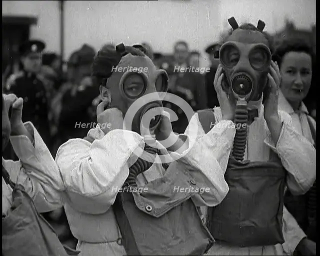 A Close up of Three Female Civil Defence Volunteers in White Boiler Suits Putting on Gas..., 1938. Creator: British Pathe Ltd.