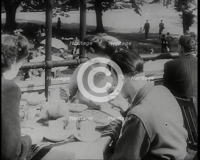 A Close up of Two Women and a Man Having Food and Drink on the Roof Terrace at  the Tea..., 1939. Creator: British Pathe Ltd.
