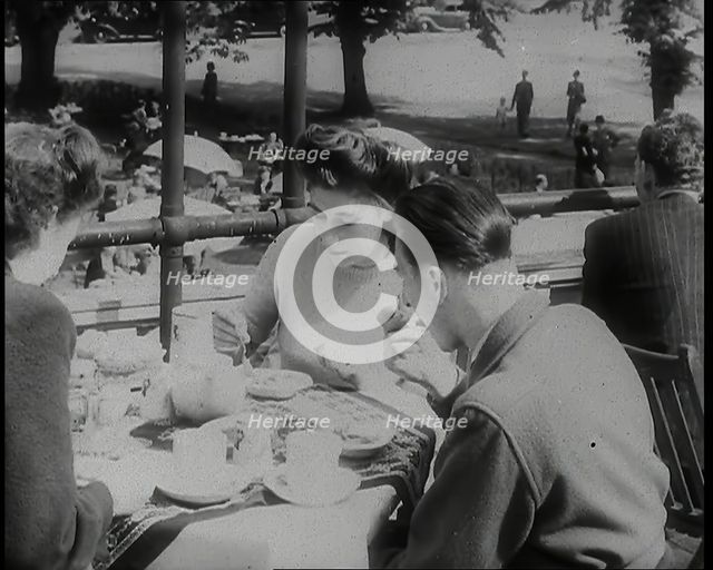 A Close up of Two Women and a Man Having Food and Drink on the Roof Terrace at  the Tea..., 1939. Creator: British Pathe Ltd.