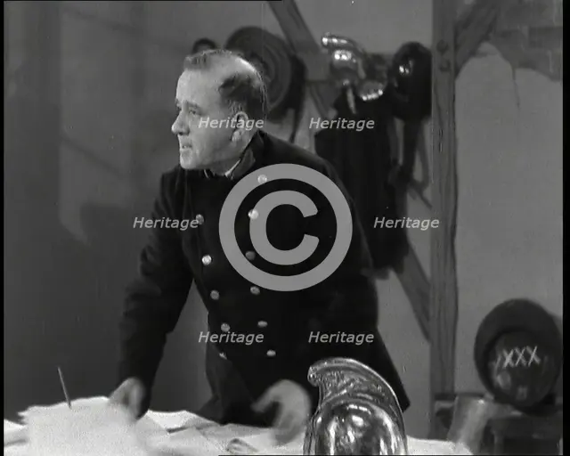 A Close up of Comedian Robb Wilton on Set Playing a Fire Brigade Officer and Standing at a..., 1938. Creator: British Pathe Ltd.