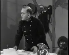 A Close up of Comedian Robb Wilton on Set Playing a Fire Brigade Officer and Standing at a..., 1938. Creator: British Pathe Ltd