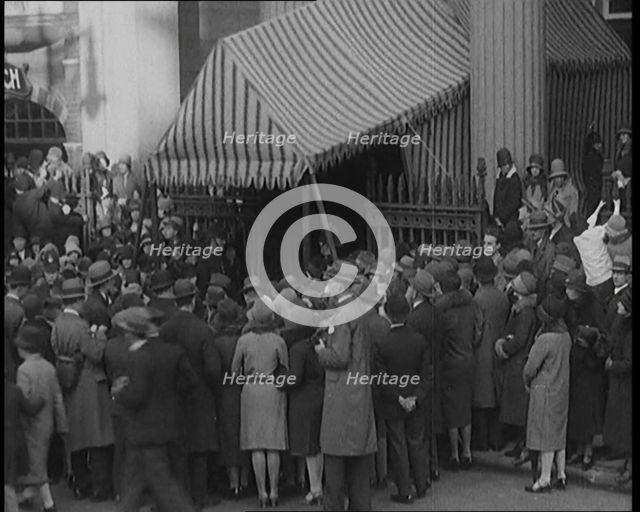 A Crowd of Civilians Gathering Under a Canopy Wearing Smart Outfits and Hats, 1920. Creator: British Pathe Ltd.