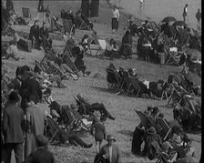 A Crowd of Civilians Sitting on Deckchairs at the Beach, 1926. Creator: British Pathe Ltd