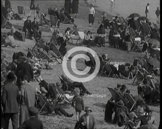 A Crowd of Civilians Sitting on Deckchairs at the Beach, 1926. Creator: British Pathe Ltd.