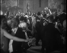 A Crowd of People Dancing at a Fancy Dress Party Whilst a Band is Playing on the Stage, 1920s. Creator: British Pathe Ltd