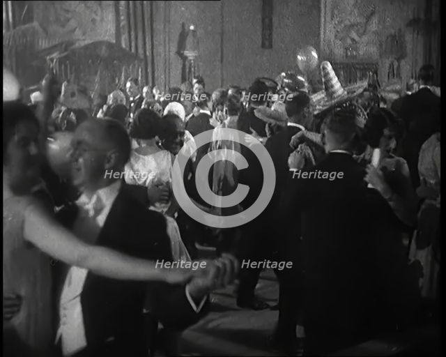 A Crowd of People Dancing at a Fancy Dress Party Whilst a Band is Playing on the Stage, 1920s. Creator: British Pathe Ltd.