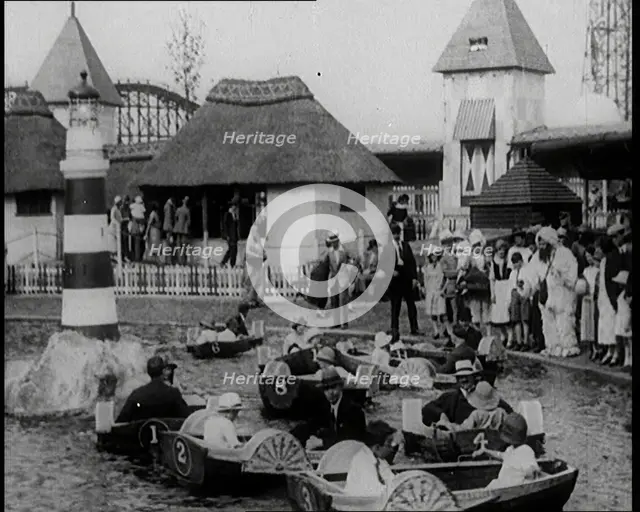 A Crowd of People Standing By a Boating Lake and Watch Other People in Paddle Boats, 1924. Creator: British Pathe Ltd.