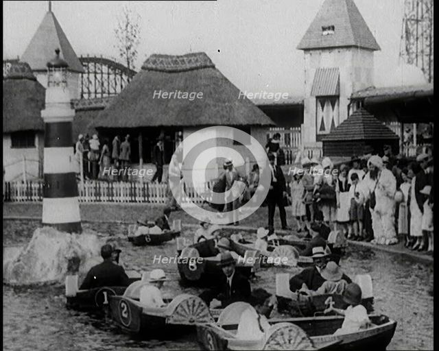A Crowd of People Standing By a Boating Lake and Watch Other People in Paddle Boats, 1924. Creator: British Pathe Ltd.