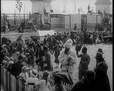 A Crowd of People Watch as Others Ride a Model Train Which Passes Them, 1924. Creator: British Pathe Ltd