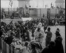A Crowd of People Watch as Others Ride a Model Train Which Passes Them, 1924. Creator: British Pathe Ltd