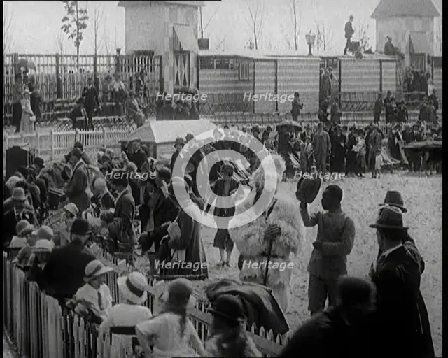 A Crowd of People Watch as Others Ride a Model Train Which Passes Them, 1924. Creator: British Pathe Ltd.