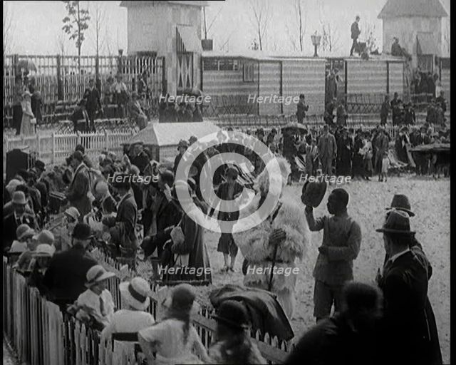 A Crowd of People Watch as Others Ride a Model Train Which Passes Them, 1924. Creator: British Pathe Ltd.