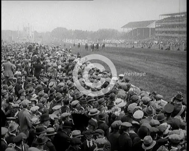 A Crowd of People Watching Horses Racing at Ascot Race Track, 1924. Creator: British Pathe Ltd.
