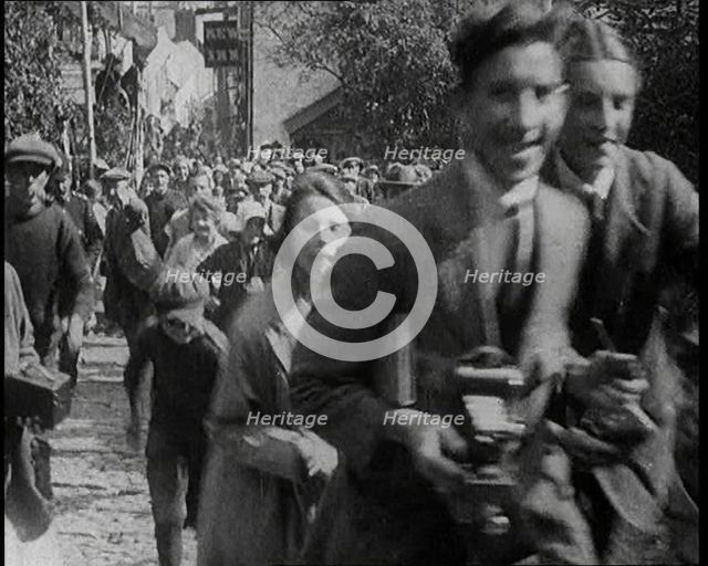 A Crowd Running up a Hilly Cobbled Street, 1920. Creator: British Pathe Ltd.