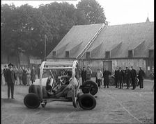 A Crashable Car With a Circular Frame Allowing It To Roll Over Being Tested in Front of..., 1926. Creator: British Pathe Ltd