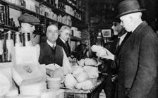 A customer inspects a haggis, London, 1926-1927