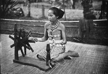 A Dayak girl at her spinning wheel, 1902