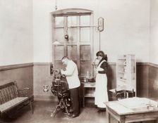 A dentist and his nurse give a schoolboy his treatment, 1910s. Creator: Unknown