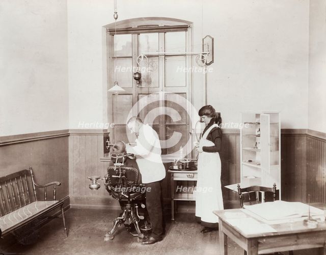 A dentist and his nurse give a schoolboy his treatment, 1910s. Creator: Unknown.